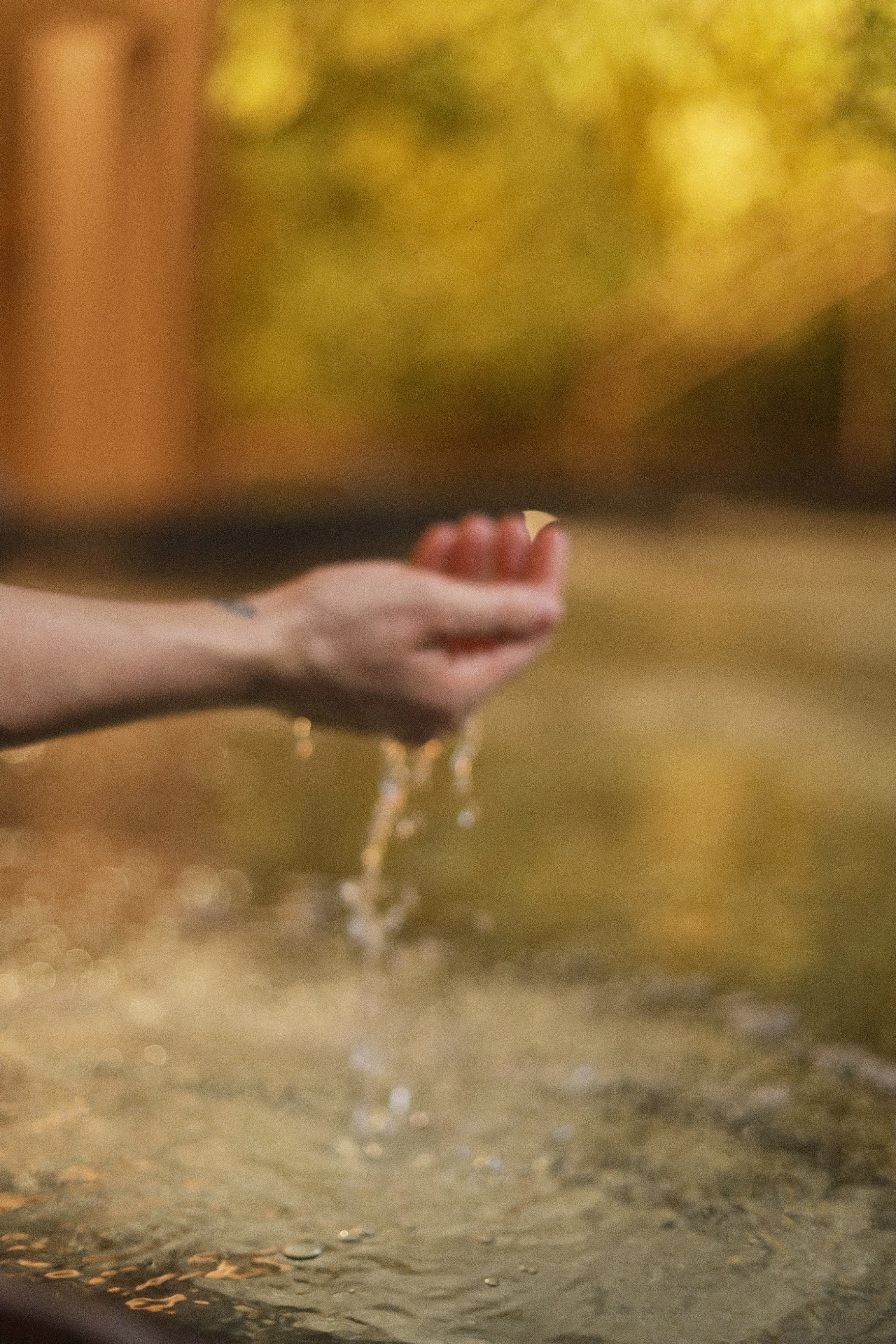 Mão tocando a água aquecida da jacuzzi do Kairós Spa